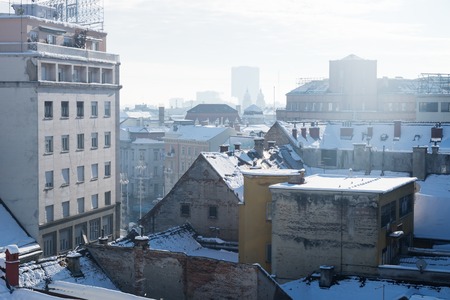Panorama view over Zagreb with smoking chimneys during winter with snow over the roofs during sunny weather, Zagreb, Croatia, Europeの写真素材
