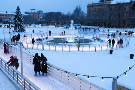 Zagreb, Croatia: January 6 2016: Ice skating park at Ledeni Park at night in winter with snow with visitors skating around the fountainのeditorial素材