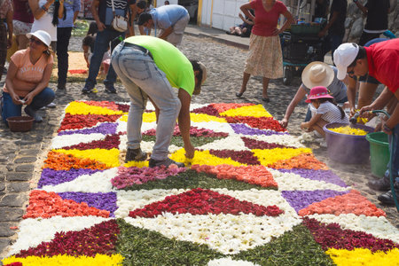 Antigua, Guatemala: March 18 2018: Locals working on alfombres, flower carpets with blossoms and...