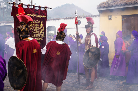 Antigua, Guatemala: March 18 2018: Man with roman soldier smiling at the procession of San Bartolome de Becerra in 1a Avenida, full of incense smokeのeditorial素材
