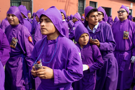 Antigua, Guatemala: March 18 2018: Young purple robed men cueing at the procession of San Bartolome...