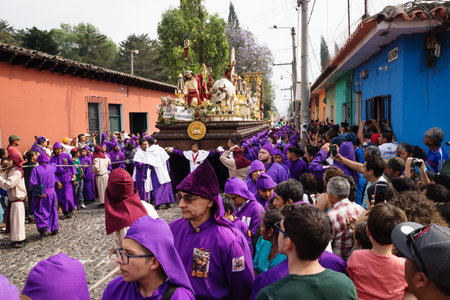 Antigua, Guatemala: March 18 2018: Visitors watching purple robed men carrying a float with Christ and a cross at the procession of San Bartolome de Becerra in 1a Avenidaのeditorial素材