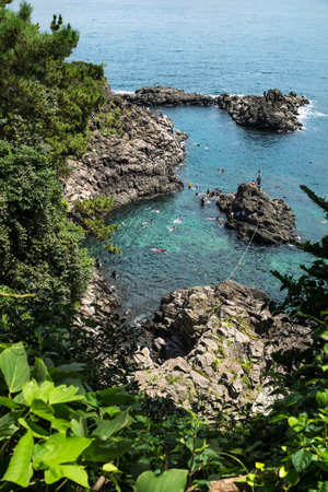 Seogwipo, Jeju Island, Korea - August 26 2017: People swimming and snorkeling along the coastline of Seogwipo in the ocean along the cliffsのeditorial素材