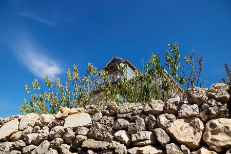 Traditional lebanese house with green dry fence with blue sky in Rachaiya, Bekaa valley, Lebanonの写真素材