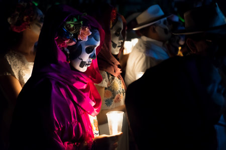 Merida, Cementerio General, Mexico - 31 October 2018: Close up of customed women dressed as Catrinas with skull make-up holding candles at the procession and parade for dia de los muertos at the Festival Des Las Animasのeditorial素材