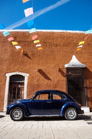Valladolid, Mexico - 29 January 2019: VW beetle in front of brown colonial building with flags on blue sky in Yucatanのeditorial素材