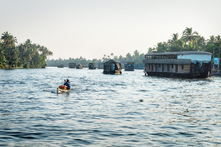 Alleppey - Alappuzha, India - 13 November 2017: Last sun on house boats on the river of the Kerala backwaters with tropical palm treesのeditorial素材