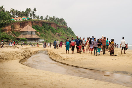 Varkala, Kerala, India - 19 November 2017: Local tourists walking along a river at the temple Varkala Bali Mandapam at the beach of Varkala during sunsetのeditorial素材