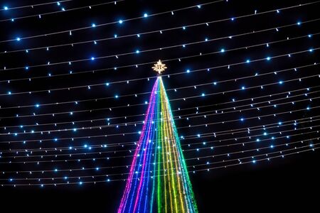 Colorful lights in a Christmas tree with power lines with star at the top at Remate de Paseo...