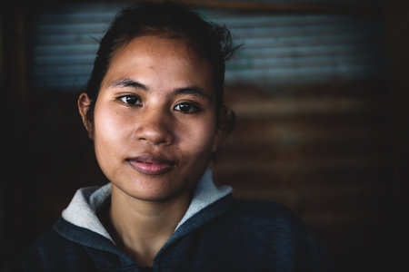 Sangkat Krabei Riel, Siem Reap Province, Cambodia - 4 April 2013: Young Cambodian woman in jumper in a province shop in the market, Siem Reap Province, Cambodiaのeditorial素材