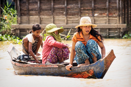 Puok, Siem Reap Province, Cambodia - 4 April 2013: Local Cambodian girls boating along Tonle Sap lake at floating villageのeditorial素材