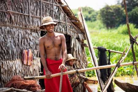 Puok, Siem Reap Province, Cambodia - 4 April 2013: Local Cambodian man at house along Tonle Sap at floating villageのeditorial素材
