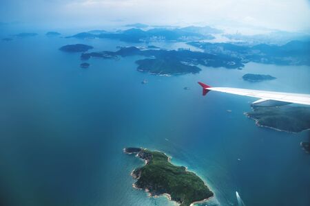 Aerial view of Hong Kong islands from a flying airplane with wing, Chinaの写真素材