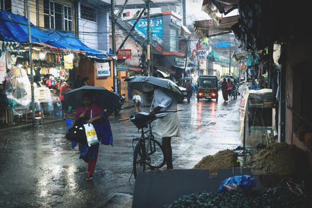 Thiruvananthapuram, Kerala, India - 30 November 2017: Local Indian people with umbrellas on a shopping street during heavy rainのeditorial素材