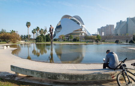 Valencia, Spain - 17 February 2020: Man sitting at pond at Palau des Arts Reina Sofia in the City of Arts and Sciences designed by architects Santiago Calatrava and Felix Candelaのeditorial素材