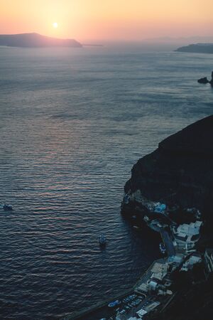 Sunset harbor orange sunset along the cliffs at Fira, Santorini, Greeceの写真素材
