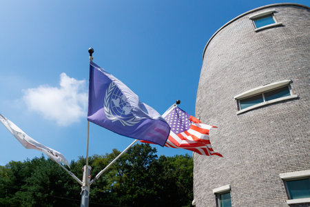 US and UN flag blown by the wind in front ot JSA Visitor Center in the border zone DMZ between North and South Koreaのeditorial素材