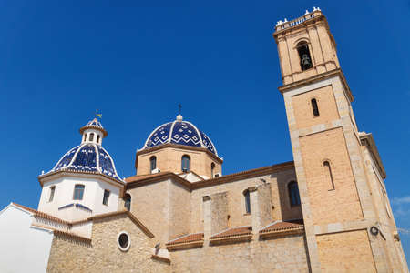 Our Lady of Solace Church with blue tiled domes and bell tower and cloudless blue sky in Altea, Costa Blanca, Spainの写真素材