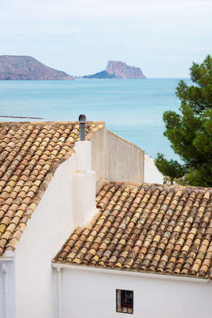 View over the ancient roof of traditional Spanish house of old town to the ocean and the rock of Calpe, Altea, Costa Blanca, Spainの写真素材