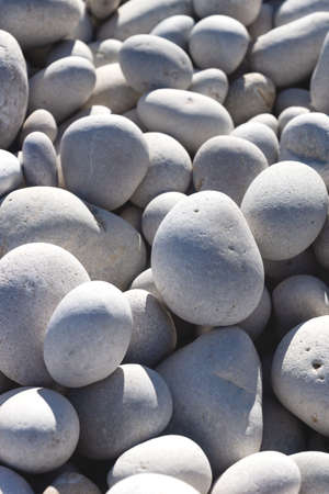Detail up of bright white and grey stones at a sunny beach