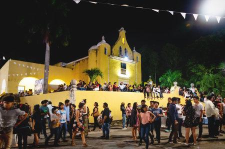 Merida, Mexico - 31 October 2018: Visitors at the festival for day of the dead sitting and walking at the colonial church 'Santa Isabel' at nightのeditorial素材