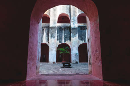 View through arch into patio with palm tree in the former monestary Convent de San Bernardino de Siena in Valladolid, Yucatan, Mexicoの写真素材