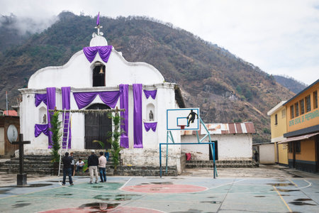 Santa Cruz la Laguna, Guatemala - 29 March 2018: Local men decorating the church with purple cloth and branches for easter in the mountain villageのeditorial素材