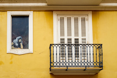 Valencia, Spain - 18 February 2020: Detail of the facade of historical Spanish house with balcony and fresco painting showing a woman looking out of a windowのeditorial素材