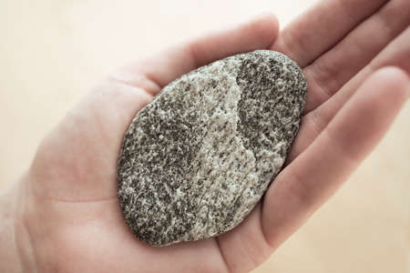 Woman holding brightly lit round shaped stone as a symbol of harmony