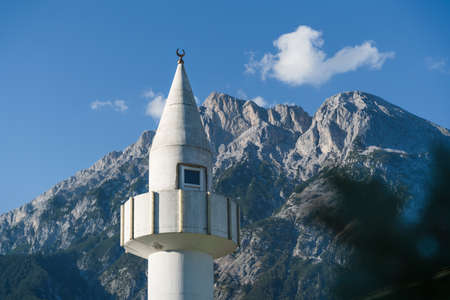 Minaret tower of a mosque in front of sunny rocky Austrian alps in Telfs, Tirol, Austriaの写真素材