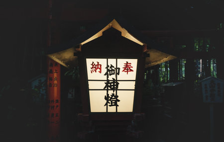 Kyoto, Japan - September 18, 2017: Enlightened Japanese lantern in front of torii gate at Nonomiya Shrine in the eveningのeditorial素材