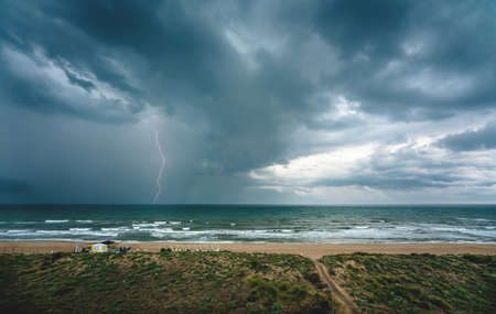 Lightning flash and dark thunderstorm over the ocean along the Mediterranean coast in Daimus, Spainの写真素材