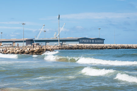 Gandia, Spain - 26 July 2021: Fishermen on a rock dam surrounded by high waves at the industrial portのeditorial素材