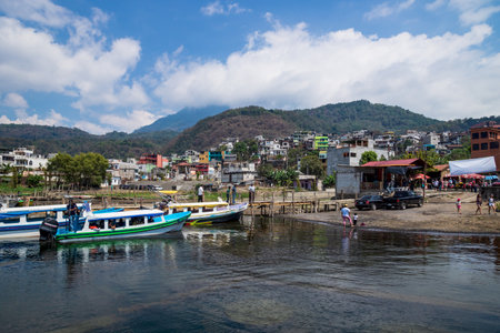 Santiago Atitlan, Guatemala - March 20, 2018: Sunny jetty at the coast of lake Atitlan with view on colorful houses in Santiago Atitlan, Guatemalaのeditorial素材