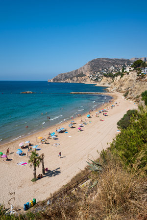 Calpe, Spain - 19 July 2021: Sand beach with tourists for leisure, swimming and sun bathing along coastlineのeditorial素材