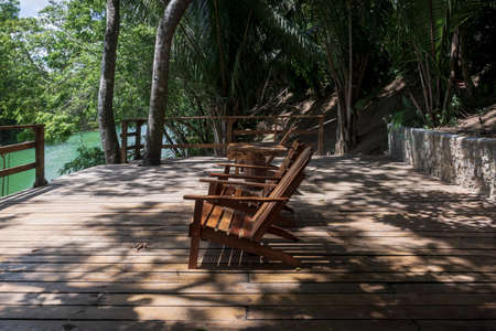 Idyllic river side dock with wooden chairs for swimming surrounded by lush tropical jungle at Mopan river, Bullet Tree Falls, Belizeの写真素材