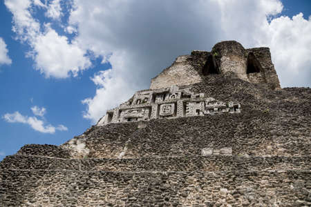 Carvings of the Maya pyramid 'El Castillo' at the archeological site Xunantunich with cloudscape...