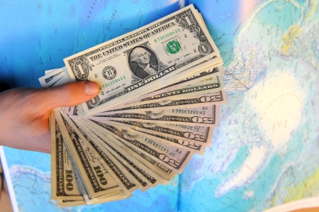 A Hand holding a small bunch of old wrinkled US Dollarsの写真素材