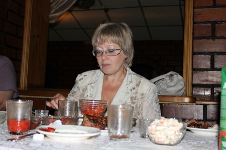 woman in a white blouse is eating in the cafeの写真素材