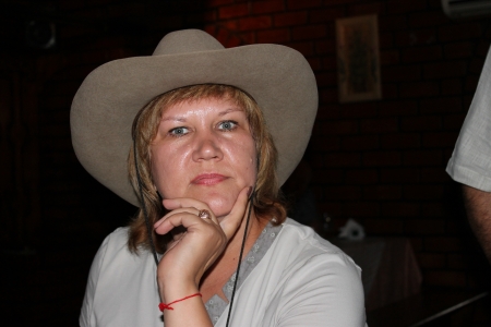 A girl in a cowboy hat watching with interestの写真素材