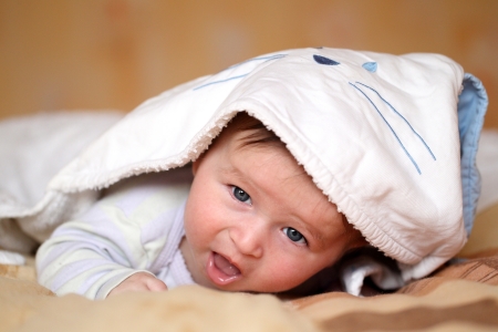 Portrait of a smiling baby 4 months old lying on his bellyの写真素材