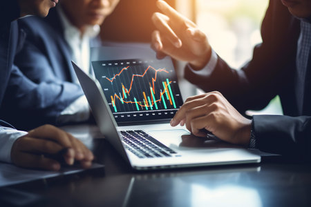 ONLINE ADVERTISING Business team hands at work with financial reports and a laptopの素材