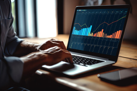 Businessman analyzing growth graph chart through laptop while planning at creative workplace, busineの素材