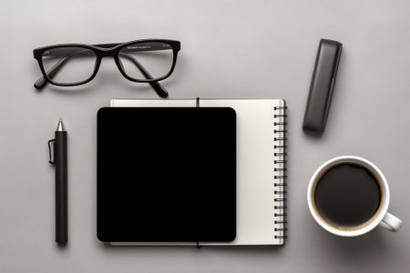Modern white office desk table with laptop computer, smartphone with black screen over a notebook anの素材