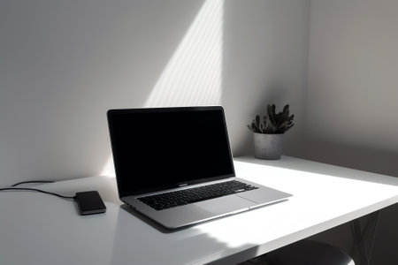 Laptop with blank screen and smartphone on table.の素材