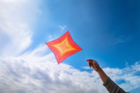 Generative AI : Colorful plane kite toy made from plastic foam is flying on blue sky backgroundの素材