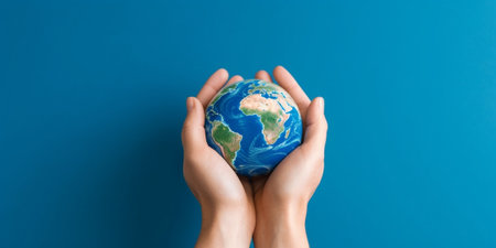 Generative AI : Mans hand picking up the earth with blue sky backgroundの素材