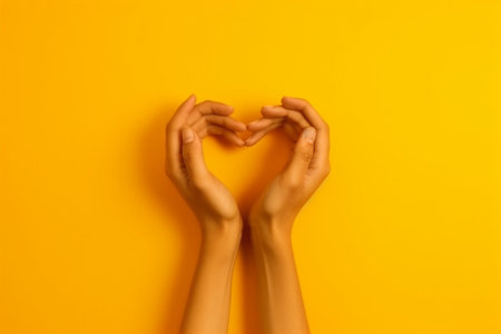 Generative AI : Hands making heart shape isolated on a yellow background  Love and minimal fashion conceptの素材