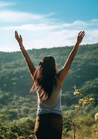 Generative AI : Happy female hiker standing on a cliff with her arms up in the air feeling free Active healty conceptの素材