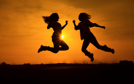 Generative AI : Silhouette of a couple in love jumping with raised arms on a wheat field at sunsetの素材